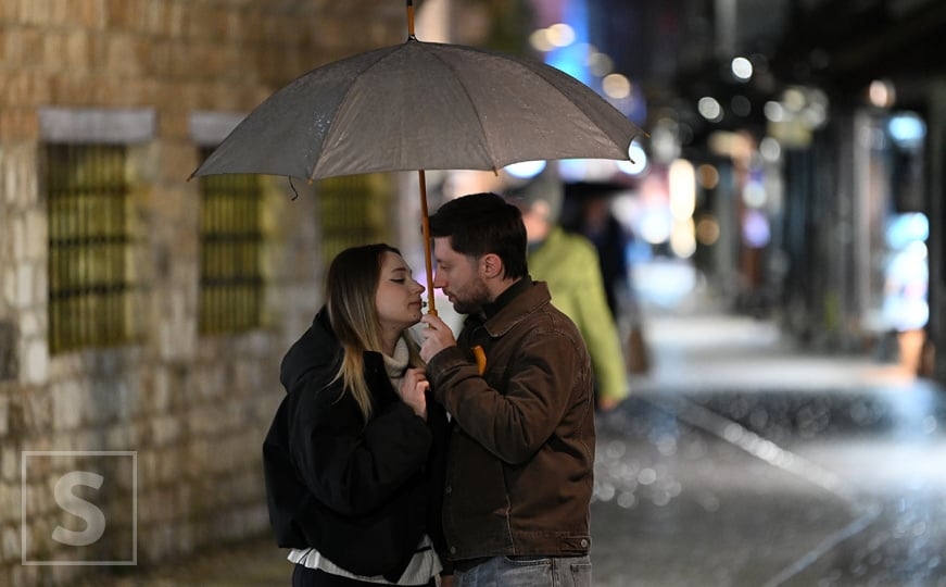 Kišna noć u Sarajevu: Ljudi pod kišobranima, i mokre ulice širom grada